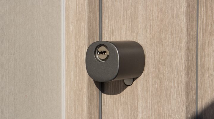 Pomolo esterno con chiave di un cilindro europeo smart montato a filo su una porta d'ingresso in legno